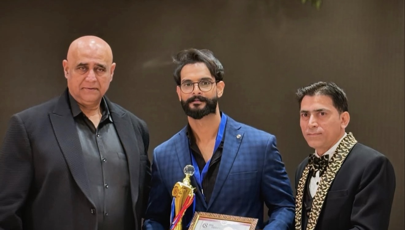 Ansh Verma receiving an award on stage